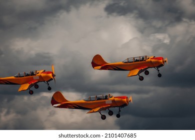 The aerobatic team performs a spectacular loop maneuver during the airshow display program, showcasing precision flying skills and synchronized formation against the backdrop of a clear sky.