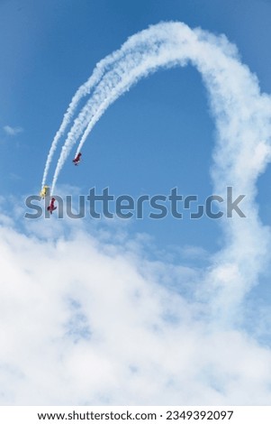 Similar – Red plane with propeller flying upward with white smoke