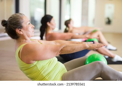 Aerobics pilates women with toning balls in a row on fitness class