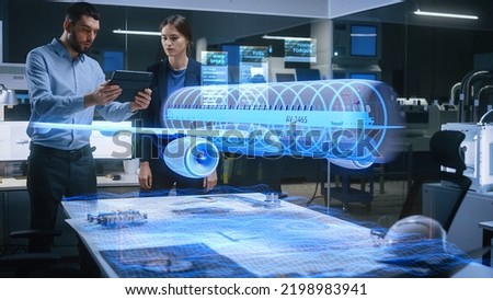 Aeronautics Factory Office Meeting Room: Engineer Holds Tablet Computer, Showing Augmented Reality Airplane Jet Engine to a Female Manager. Modern Industry 4.0 Project Research and Development Test.