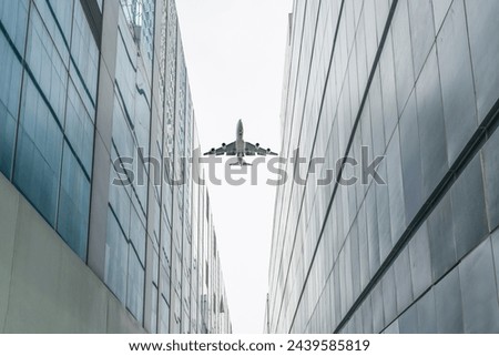 aeroplane fly over modern buildings in downtown.