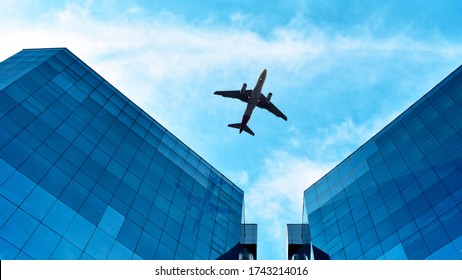 Aeroplane Flying Above Blue Buildings