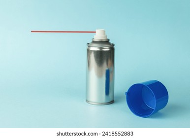 An aerosol can with lubricant on a blue background. A means for lubricating mechanisms.