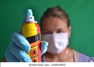 Aerosol For Insect Control In The Hands Of A Woman Wearing A Mask.