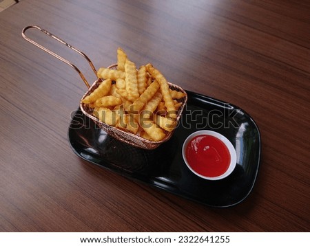 Aestetic photo of frenchfries on the woodden table. 