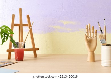 Aesthetic artist background, small easel and wooden hand mannequin, drawing class decoration - Powered by Shutterstock