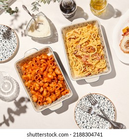 Aesthetic composition with italian pasta on white table in summer day. Set of italian pasta: spaghetti carbonara and rigatoni arrabiata. Italian pasta on ceramic plate with hard shadows