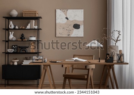 Aesthetic composition of living room interior with mock up poster frame, wooden desk, rattan chair, black rack, vase with branch, books, brown wall and office accessories. Home decor. Template.