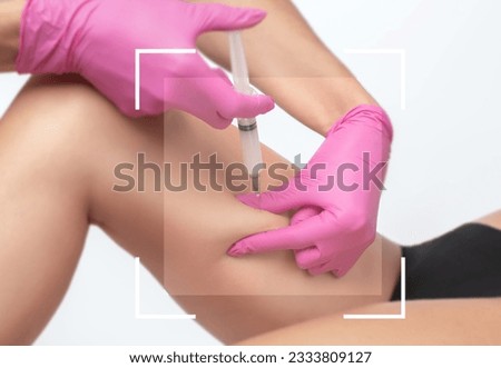 Aesthetic cosmetologist makes lipolytic injections to burn fat on the thighs, hips and body of a woman. Female aesthetic cosmetology in a beauty salon.Cosmetology concept.