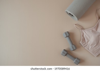 Aesthetic Creative Flat Lay Of Yoga, Fitness, Workout Training Equipment On Neutral Beige Background. Dumbbells, Top, Mat. Flatlay, Top View Sport Influencer Concept