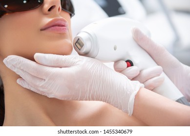 Aesthetic Face Treatment. Close Up Face Down Portrait Of Young Careful Woman Having Laser Hair Removal Procedure Of Chin Zone By Specialist In Cosmetic Center