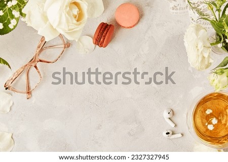 Aesthetic feminine flat lay with glasses, tea cup, macaroon and earphones background. Cozy home, biophilic interior concept. Copy space