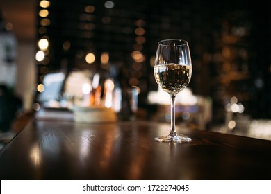 Aesthetic Glass Of White Wine Or Water With Dark Blurry Bar Background 