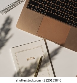 Aesthetic luxury bohemian minimalist home office workspace desk. Laptop computer, notebook, pampas grass with sunlight shadows. Flat lay, top view work, business concept - Powered by Shutterstock