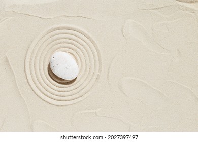 Aesthetic Minimal Background With Zen Stone On Sand. Pattern In Japanese Zen Garden With Concentric Circles Around White Pebble For Meditation And Tranquility. View From Above.