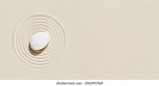 Aesthetic Minimal Background With Zen Stone On Sand. Pattern In Japanese Zen Garden With Concentric Circles Around White Pebble For Meditation And Tranquility. View From Above.