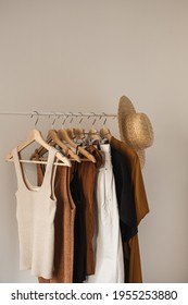 Aesthetic Minimalist Fashion Influencer Blog Composition. Stylish Pastel Summer Female Clothes, Dress, Tops, T-shirts, Straw Hat On Clothing Rack Against White Wall. Fashion Women Wear