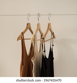 Aesthetic Minimalist Fashion Influencer Blog Concept. Summer Female Tops, T-shirts On Clothing Rack On White Wall. Fashion Women Clothes