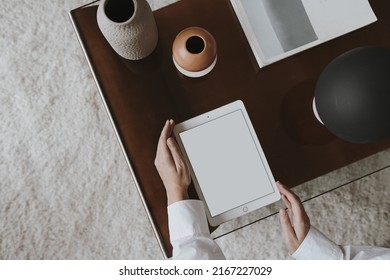Aesthetic minimalist home office workspace desk. Person using tablet pad. Blank mockup screen template. Work, business concept. Online shopping, online store branding. Flat lay, top view, above