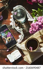 Aesthetic Outdoor Table With Glass Of Water, Cup Of Coffee, Beautiful Flowers And Lace. Phone Screen, Wireless Headphones. Aesthetic Picnic. Stylish Lifestyle Flat Lay Photography,hard Shadows