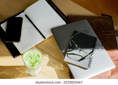 Aesthetic remote workspace with laptop and stationery. Freelancer's essentials: laptop, glasses, bag, and notebooks - Powered by Shutterstock