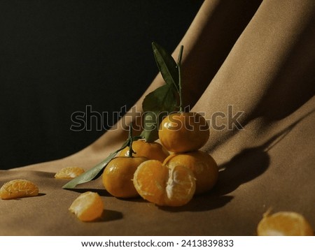 Aesthetic still life orange fruit, and lighting on brown satin tablecloth. Lifestyle, oil painting style, elegant vibes, vintage, artsy style, art. 
