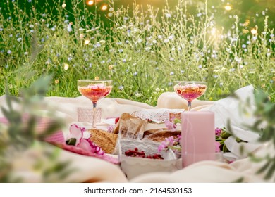 Aesthetic Summer Sunny Lunch Picnic With Baguette, Flowers, Cocktail And Berries At Pale Beige Blanket At Grass Outdoor Background With Sunbeam. Front View.