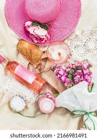 Aesthetic Summer Sunny Lunch Picnic With Baguette And Flowers, Wine And Cheese At Pale Beige Blanket With Pink Sun Hat. Top View. Outdoor