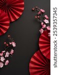 Aesthetic vertical arrangement of red paper fans and cherry blossoms on a black background, symbolizing Chinese New Year traditions and elegance