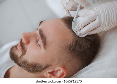 Aesthetician Giving Hairloss Treatment Injections Into Scalp Of Male Client