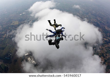 Aff instructors with student over a big cloud in free fall
