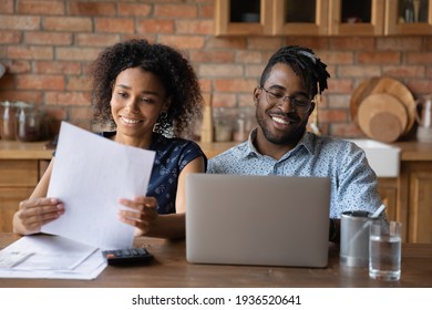 Affairs In Order. Happy Black Family Couple Engaged In Home Accounting Pay Bills Using Laptop. Young Afro American Spouses Check Review Financial Papers Feel Satisfied Glad Of Making Payments In Time