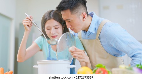 affectionate asian young couple wearing apron are cooking and they making soup together in light white interior style kitchen at home - Powered by Shutterstock