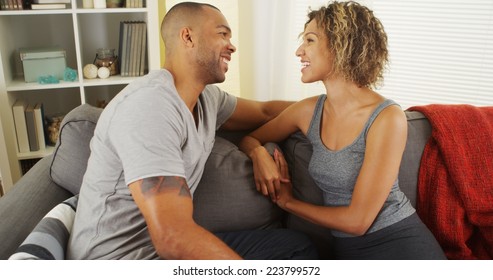 Affectionate black couple talking on couch