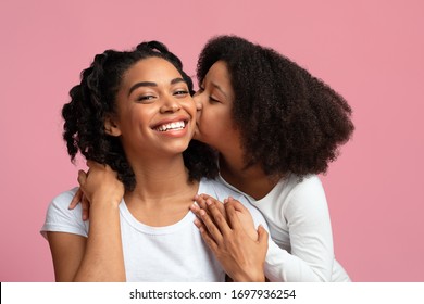 Affectionate Child. Cute Little Black Girl Tenderly Kissing Her Happy Mom In Cheek