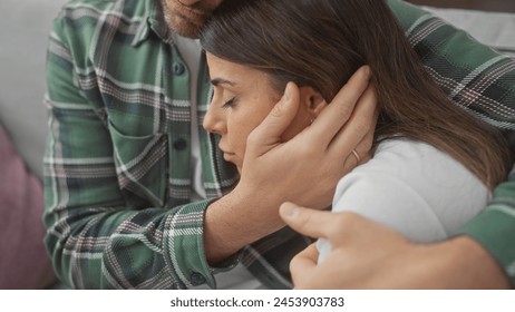 Affectionate couple embracing tenderly on a cozy sofa indoors, with the man comforting the woman in a supportive environment. - Powered by Shutterstock