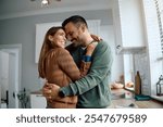 Affectionate couple embracing while enjoying in their new kitchen at home.