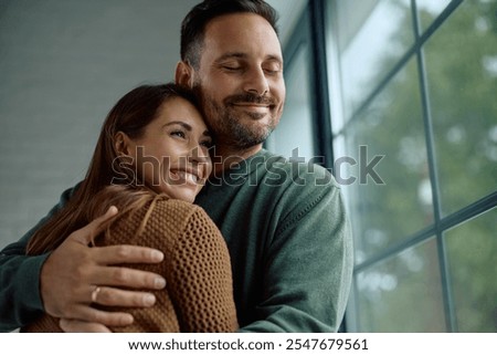 Affectionate couple embracing while spending time together at home. Copy space.