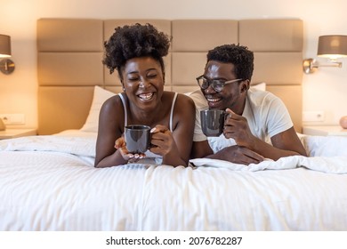 Affectionate couple enjoying morning coffee and cuddling in bed. Cropped shot of an affectionate young couple having coffee in their bedroom in the morning. Couple sharing a coffee in bed. - Shutterstock ID 2076782287