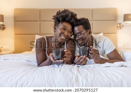Affectionate couple enjoying morning coffee and cuddling in bed. Cropped shot of an affectionate young couple having coffee in their bedroom in the morning. Couple sharing a coffee in bed.