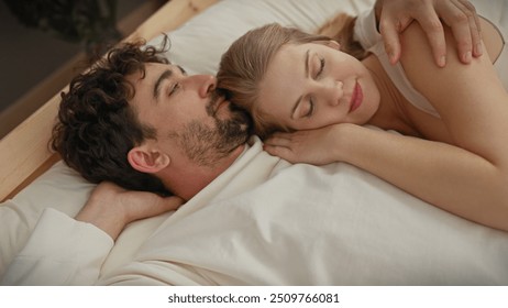 An affectionate couple enjoys a serene moment together in a cozy bedroom setting, evoking love and intimacy. - Powered by Shutterstock