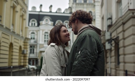 Affectionate Couple Meeting On Urban Street. Happy Man And Woman In Love Cuddling Together On City Background Outdoor. Smiling Lady And Curly Guy Enjoying Date In Old Town. Happiness Concept.