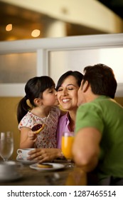 Affectionate Family Eating Breakfast Together At A Cafe.