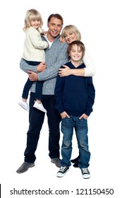 Affectionate Family Of Four Posing In Winter Outfits. Full Length Studio Shot.