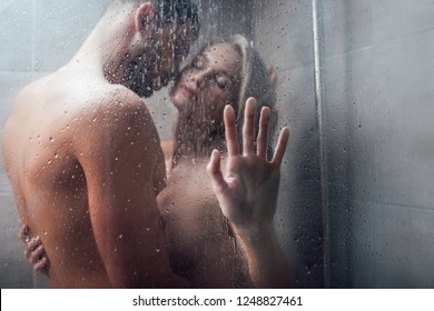 affectionate man passionately embracing beautiful woman in shower 