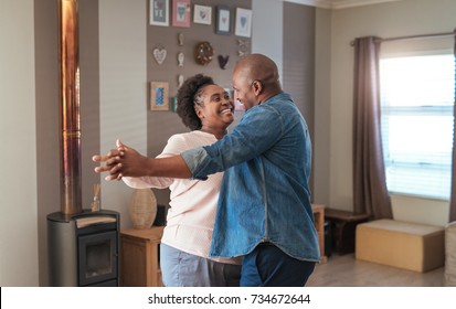 Affectionate Mature African Couple Enjoying A Playful Moment While Dancing Together In Their Living Room At Home