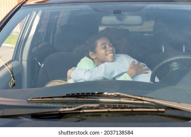 Affectionate Mom And Daughter Giving Each Other Goodbye Hug In The Car Before Going To School