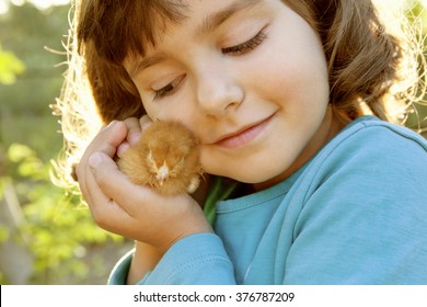 Affectionate Tender Girl Holding Chicken In Hands Like A Treasure