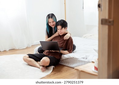Affectionate Young Couple Bonding While Watching Laptop on Floor in Bedrooom