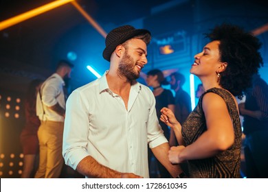 An Affectionate Young Couple Dancing On A Crowded Dance Floor In A Nightclub